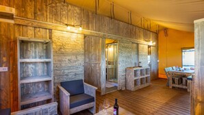 Un intérieur rustique avec des murs en bois, des sièges intégrés et un coin repas comprenant une table et des chaises.