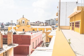 A yellow building with a dome and a red building in the foreground.