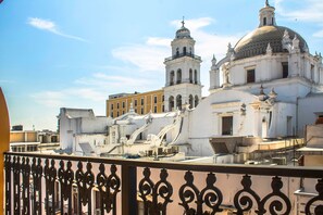 A white building with a bell tower and dome, surrounded by other buildings. - Hotel Múcara (Veracruz)