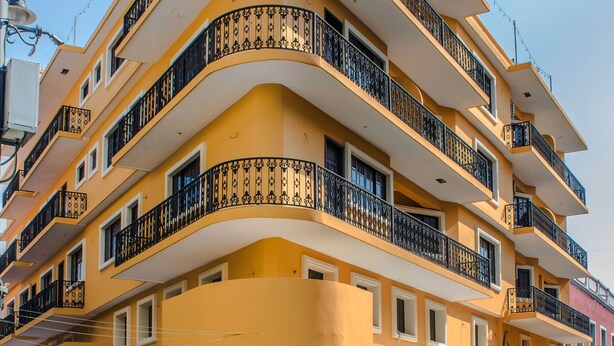 A multi-story building with balconies, a street in front, and a clear sky. - Hotel Múcara (Veracruz)