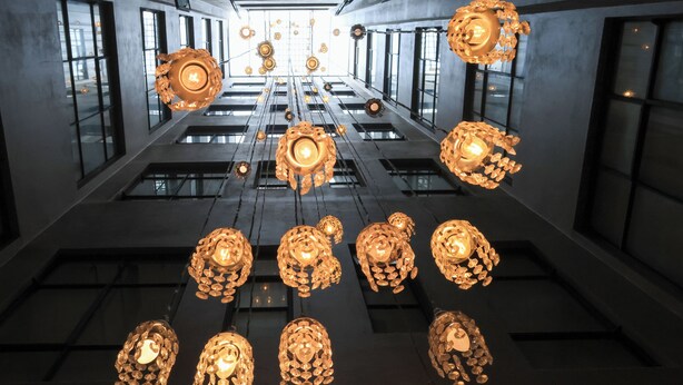A modern interior with hanging spherical chandeliers and a grid of windows. - Hotel Museo San Moritz (Bogotá)