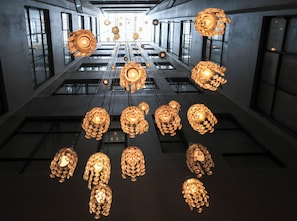 A modern interior with hanging spherical chandeliers and a grid of windows. - Hotel Museo San Moritz (Bogotá)