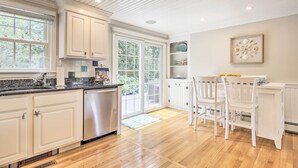 A kitchen with white cabinets, a stainless steel dishwasher, and a wooden floor. - ~ 4 Mi to Dtwn: Chatham Home w/ Fire Pit (South Chatham)