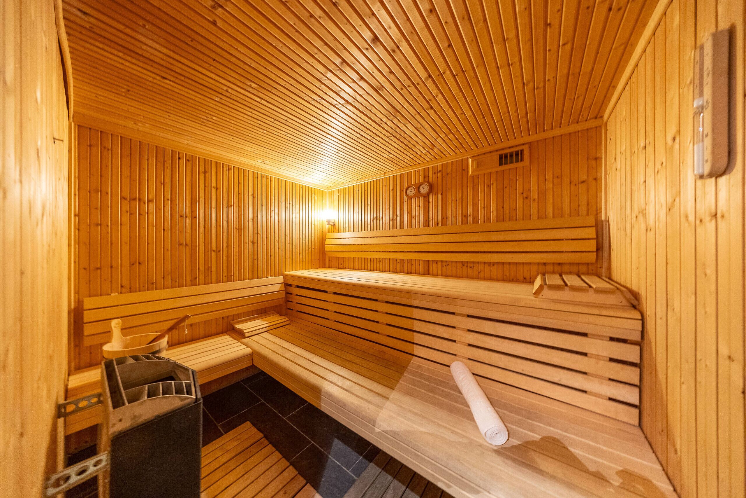 Una sauna con panche in legno e una panca con un asciugamano.