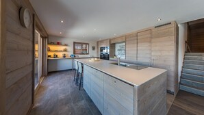 Eine moderne Küche mit Kochinsel, Holzschränken und integriertem Backofen.
