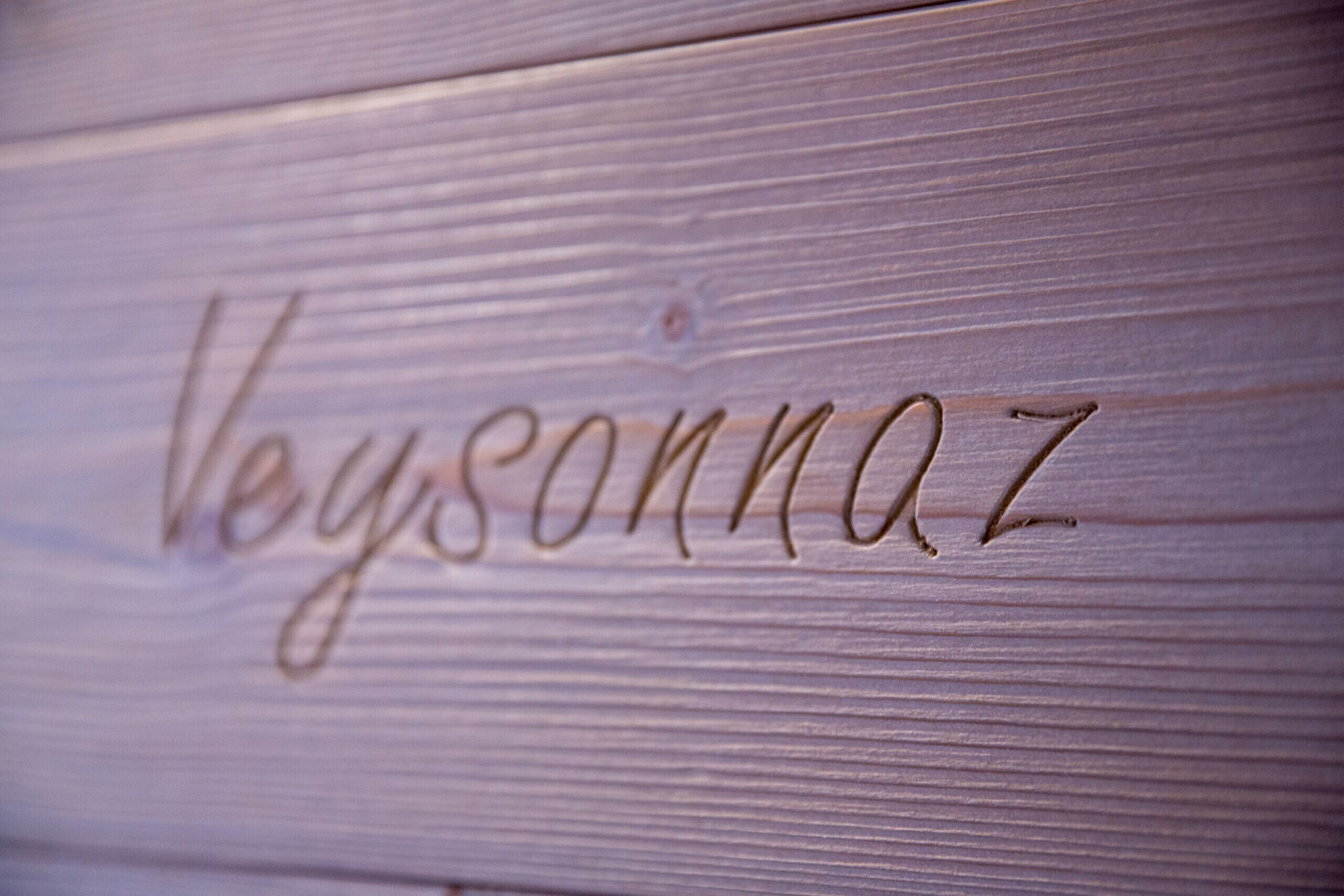 Une surface en bois sur laquelle est gravé le nom « Veysonnaz ».
