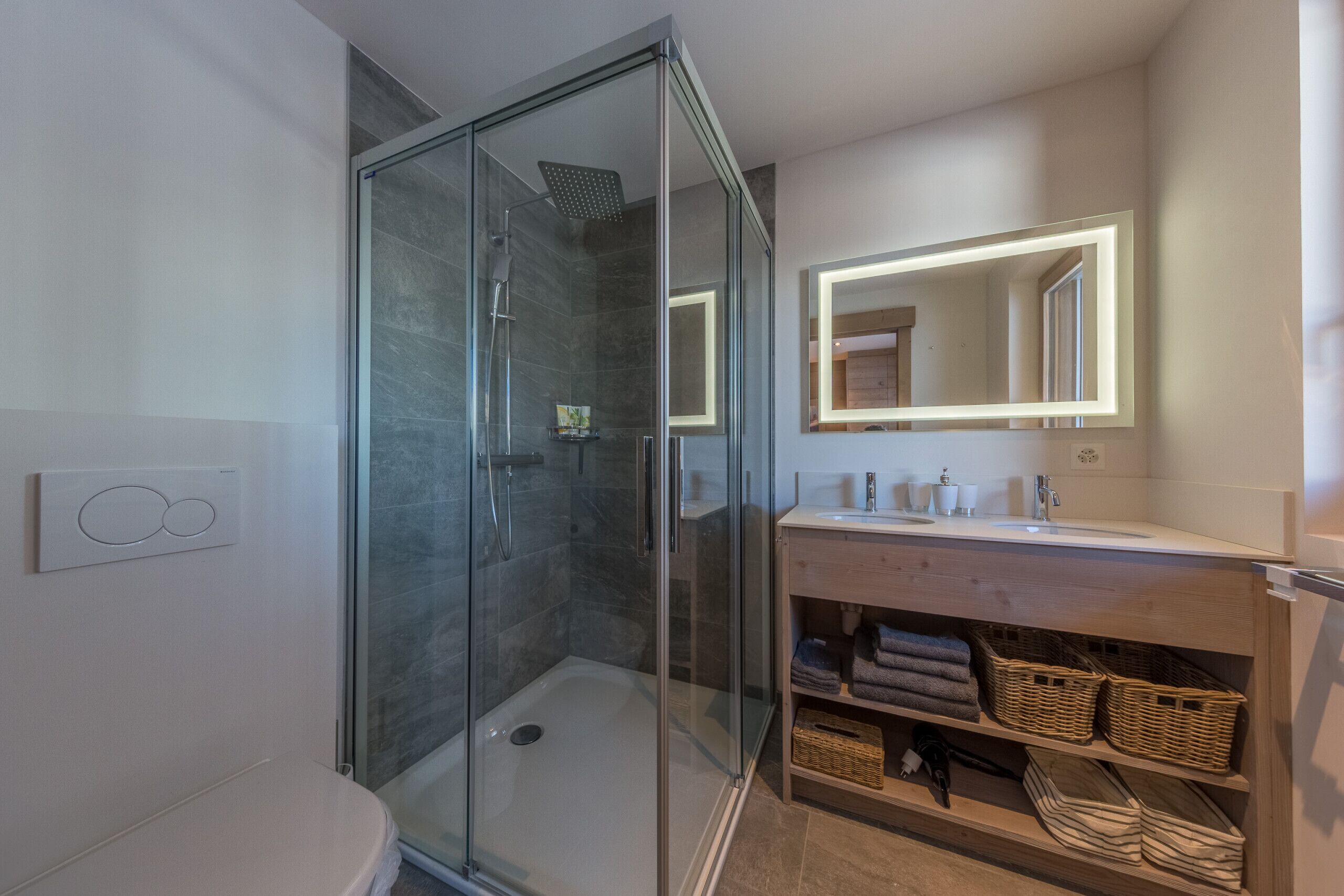Une salle de bain moderne avec une douche à parois de verre, un meuble-lavabo avec un miroir et des toilettes.