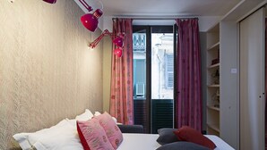 A bedroom with a bed, pillows, a desk, and a window with curtains. - Design in Genoa city center by Wonderful Italy (Genova)
