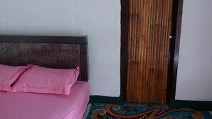 A room with a bed, a wooden door, and a patterned floor.