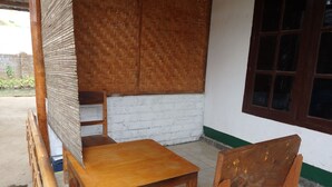 A wooden table and chairs in a room with a white brick wall and a window.
