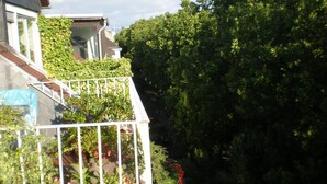A residential building with a balcony, surrounded by dense greenery and a clear sky. - bright apartment in the lively, cultural city of Mainz (Rheinland-Pfalz)