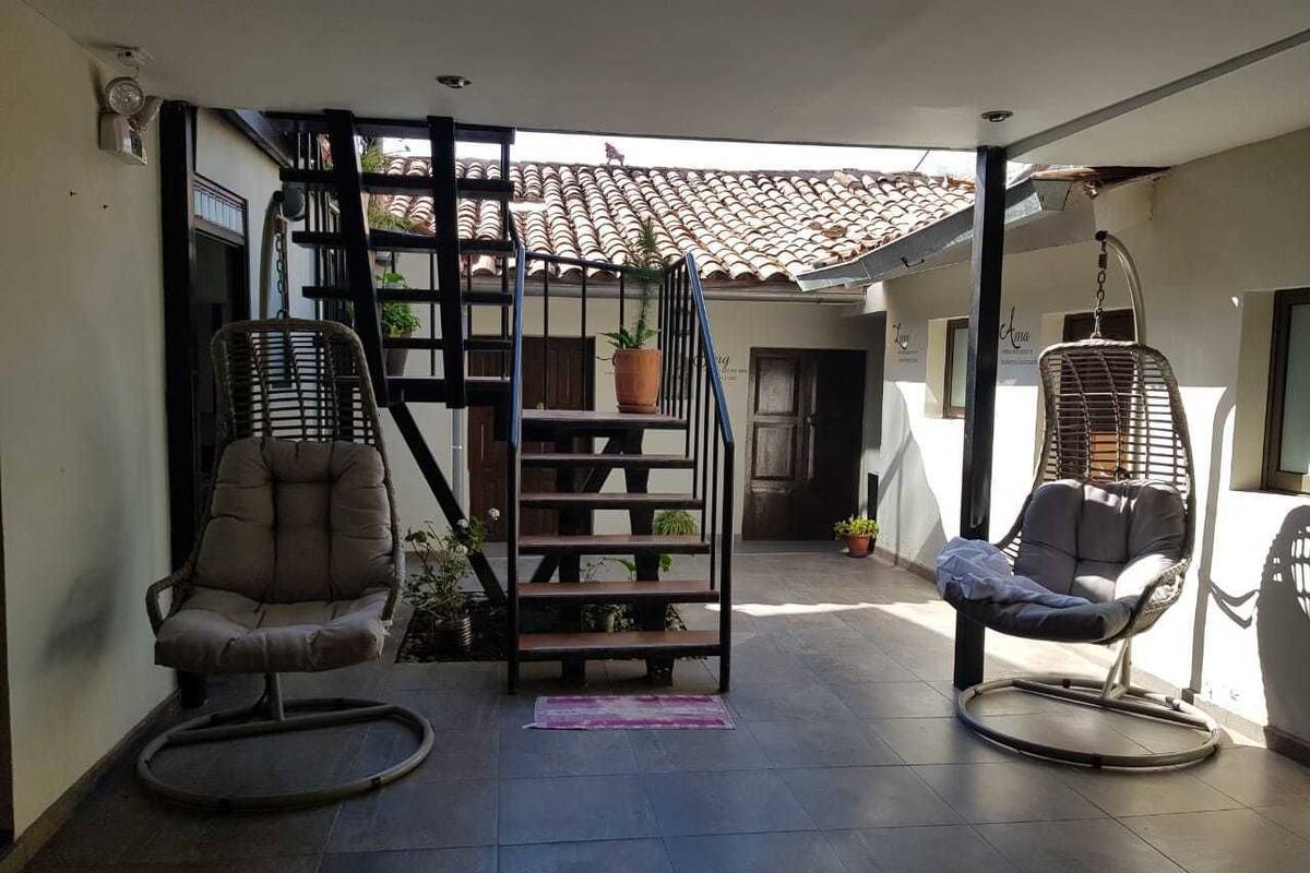 Un patio amplio con dos mecedoras, una escalera y plantas en macetas.