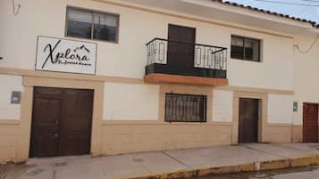 Un immeuble de deux étages sur lequel on peut lire l’inscription « Xplora Hostel Cusco ».