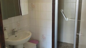 Une salle de bain comprenant un lavabo, des toilettes et un espace douche.