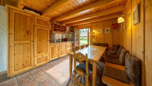 A wooden interior with a kitchen, dining area, and seating. - Chalet Pierre Blanche - Ski-in/out (Haute-Nendaz)