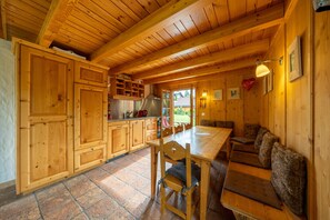 A wooden interior with a kitchen, dining area, and seating. - Chalet Pierre Blanche - Ski-in/out (Haute-Nendaz)