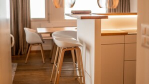 A modern kitchen with a central island, wooden flooring, and pendant lighting. - Olympic R2 - ski lift Nendaz (Haute-Nendaz)