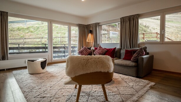 A spacious living room with a large window, a sofa, a chair, and a rug. - Olympic R2 - ski lift Nendaz (Haute-Nendaz)
