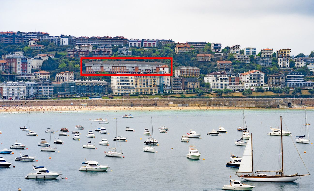 Un paysage urbain côtier avec de nombreux bateaux sur l’eau et un bâtiment identifié comme un « trésor » de l’île de Santa Clara.