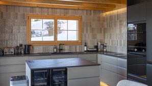 Une cuisine moderne dotée d’une grande fenêtre, d’appareils électroménagers intégrés et d’un design épuré et minimaliste.