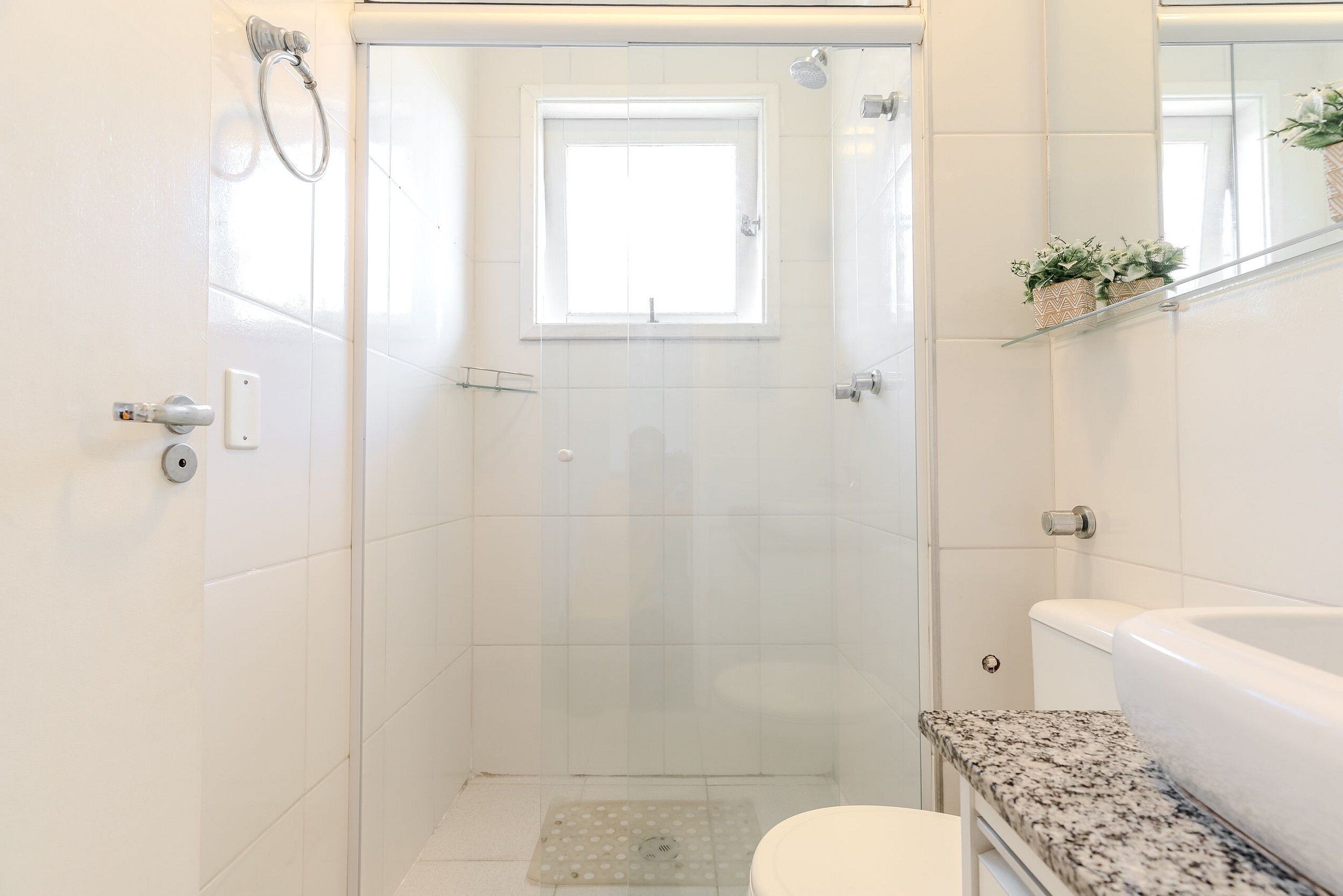 Un baño moderno con ducha envuelta en vidrio, inodoro y bañera.