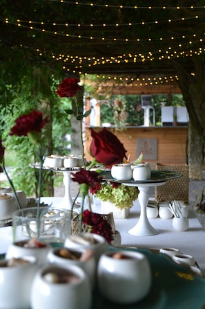A table set for a meal with white dishes and a rose centerpiece.