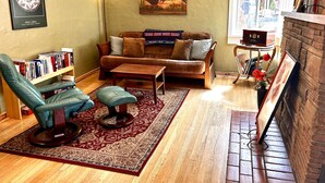 A cozy living room with a sofa, armchair, coffee table, and a bookshelf. - Cottage in Flagstaff's NoHo (Flagstaff)