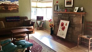A living room with a fireplace, a sofa, a coffee table, and a rug. - Cottage in Flagstaff's NoHo (Flagstaff)