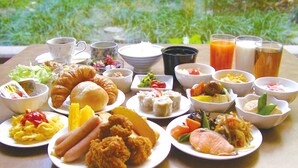 Una mesa con varios platos, incluyendo pollo frito, ensaladas y pasteles, que sugiere un ambiente para comer.