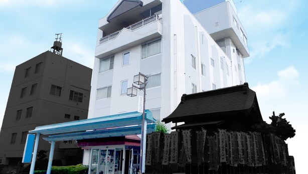 Un edificio moderno con un toldo azul y una puerta japonesa tradicional.