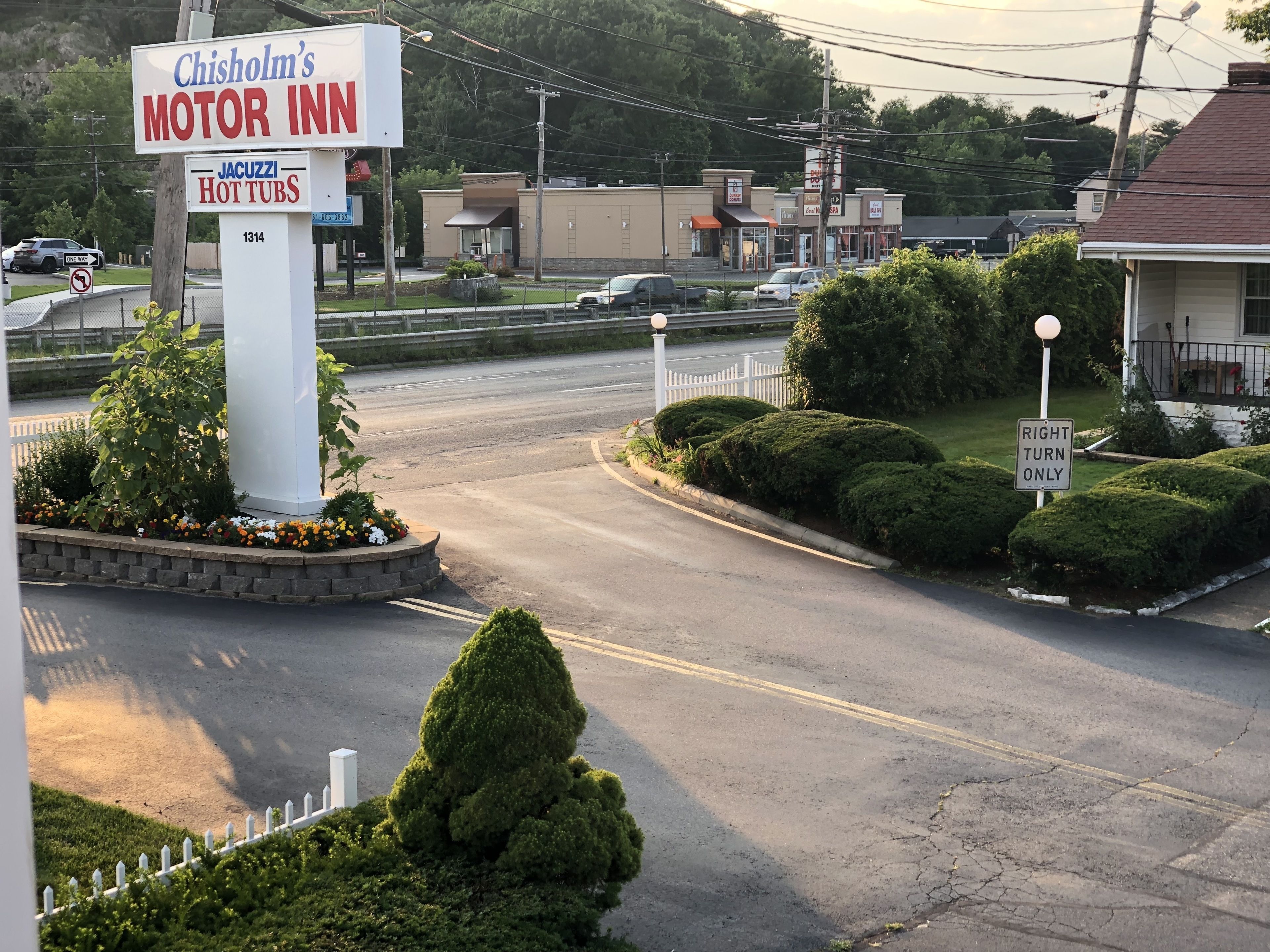 A commercial area with a sign for Chisholm's Motor Inn and a Jacuzzi Hot Tubs sign.