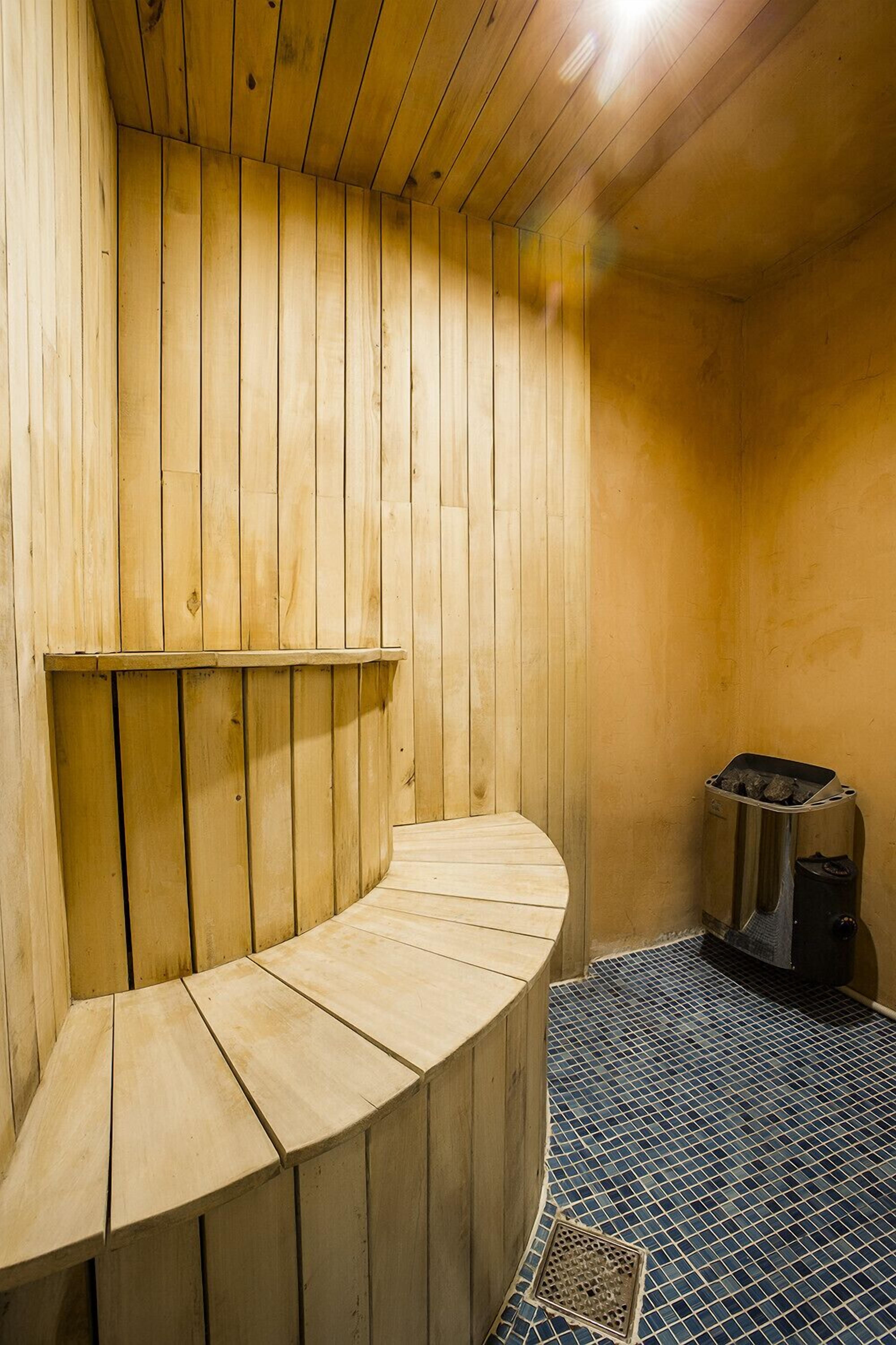 A sauna with wooden walls and a tiled floor.
