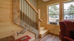 A wooden staircase with a metal railing, a window with a view of trees, and a chair. - LOVELY, LUXURY, NEW BIG SEBAGO HOUSE, WATER ACCESS,
INCLUDES DOCK & MOORING  (Standish)