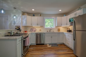 Enjoy cooking in this well-lit kitchen with an oven, stainless steel dishwasher, and refrigerator.