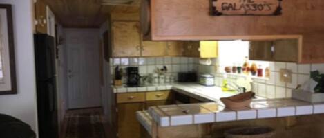 Una cocina con armarios de madera, salpicadero azulejado y un cartel que dice 'THE GALASSO'S'.