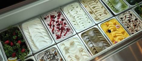 A variety of ice cream flavors in a metal container.