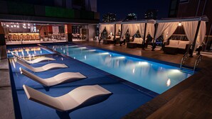 Zona de piscina con sillones de descanso y un bar.