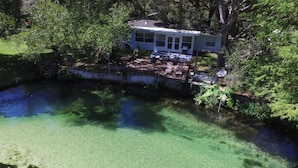A house with a clear view of a pond and surrounding greenery.