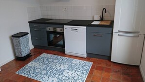 Eine kleine Küche mit Geschirrspüler, Backofen und Spüle.