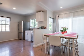 Enjoy meals in the kitchen with a central island and dining area featuring a table and chairs.