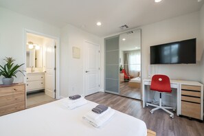 Relax in a stylish room with a comfortable bed, desk, and balcony access.