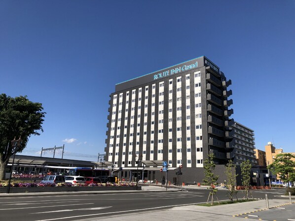 A multi-story hotel with a modern design, featuring a prominent sign at the top. - Hotel Route-Inn Grand Ota Ekimae (Ota)