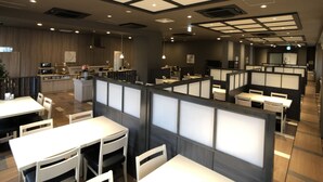 A modern restaurant interior with high ceilings, recessed lighting, and a mix of booth and table seating. - Hotel Route-Inn Grand Ota Ekimae (Ota)