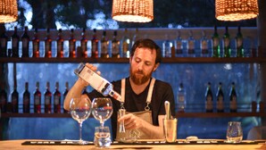 A bartender pouring a drink into a glass at a bar with a variety of bottles in the background. - Estancia Anastasio by Folk (Maldonado)