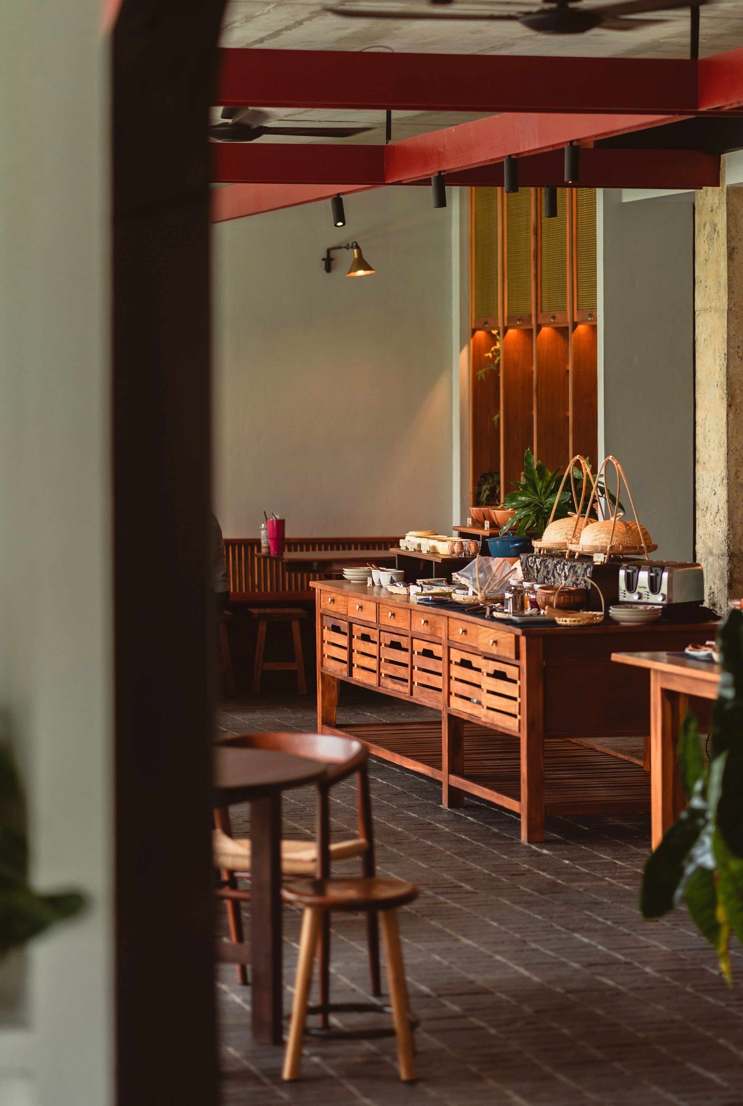 Un restaurante acogedor con mobiliario de madera, una isla central con diversos objetos y un ambiente cálido.