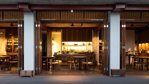 A restaurant with a traditional wooden interior, multiple dining tables, and chairs.