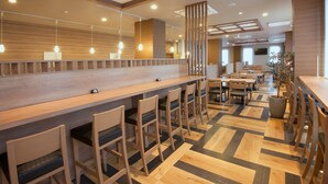 Un intérieur de restaurant moderne avec des comptoirs de bar en bois, des tabourets de bar et un sol à motifs.