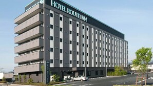 Un hôtel moderne, avec une enseigne, plusieurs étages et un parking.