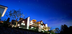 A modern two-story house with a balcony, surrounded by a stone wall and a green fence. - In My Dream Pension Gapyeong (Gapyeong)
