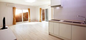 A modern kitchen with a built-in dishwasher, a large window with curtains, and a view of a balcony. - In My Dream Pension Gapyeong (Gapyeong)